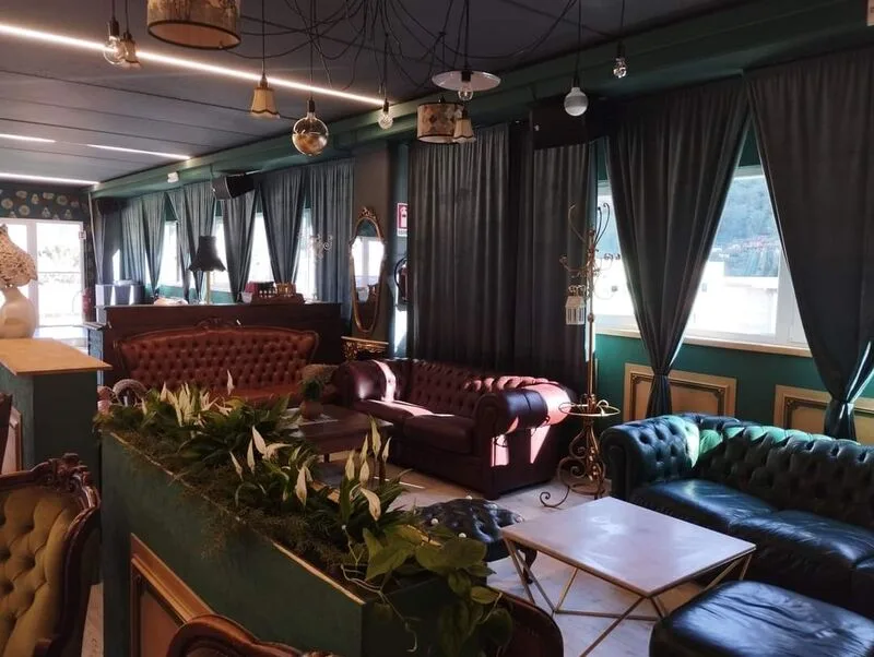 Sala lounge del Tira Tardi Ristopub Sala lounge del Tira Tardi Ristopub a Cannobio, con divani in velluto verde e pelle bordeaux